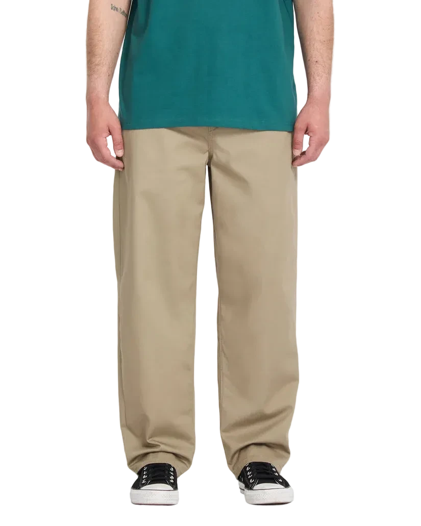 Person wearing a green shirt and beige pants fit