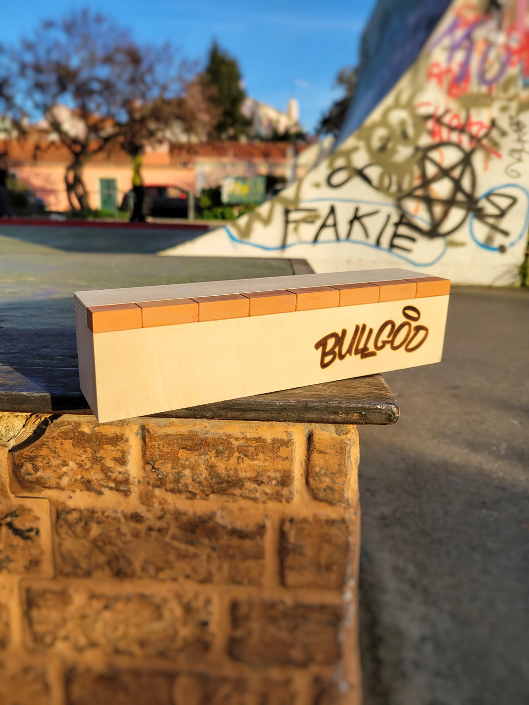 Skateboard deck with 'Bulldog' branding on a ledge at a skate park.