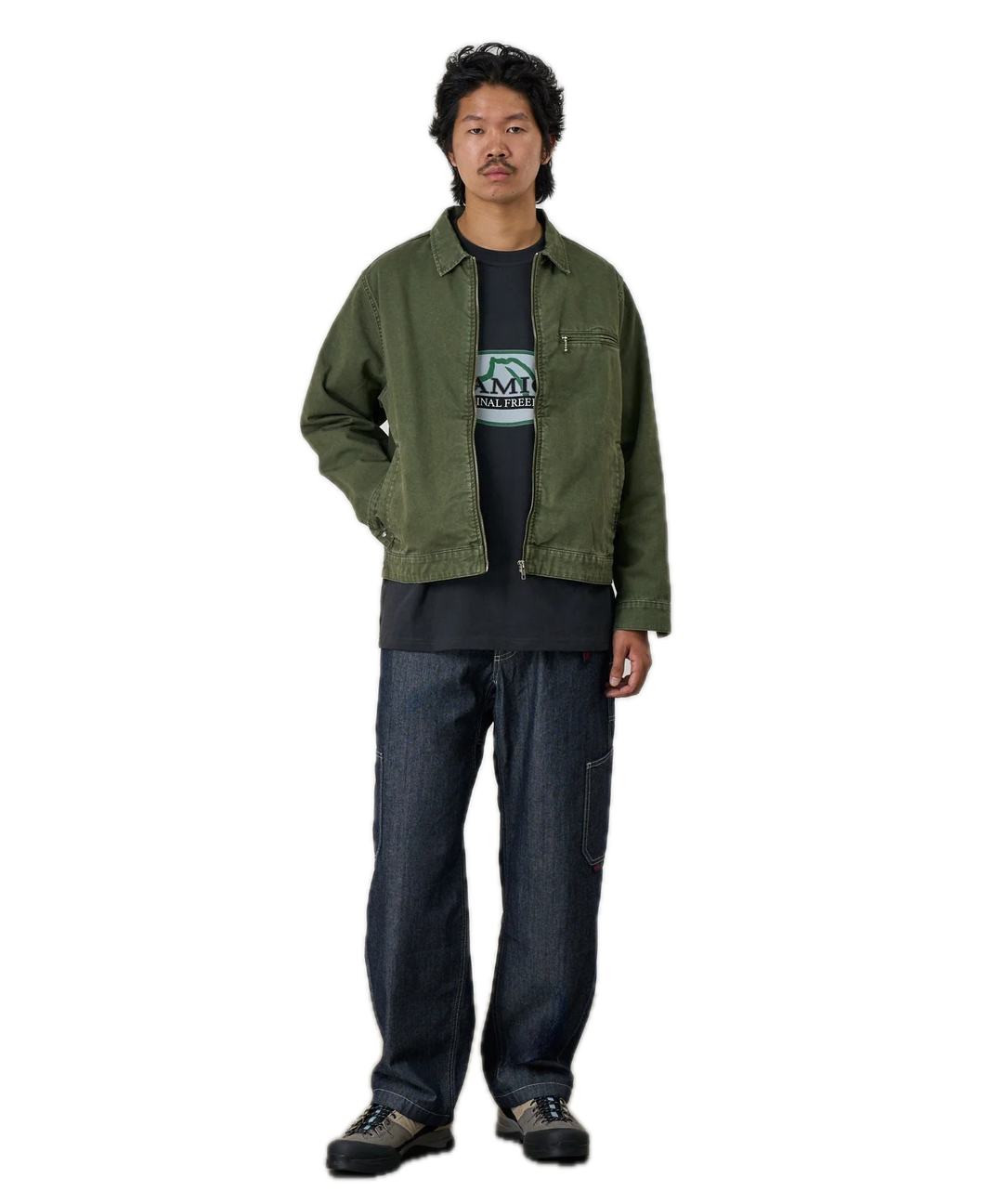 Person wearing a green jacket and dark jeans 