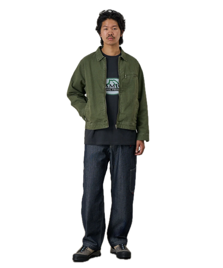Person wearing a green jacket and dark jeans 