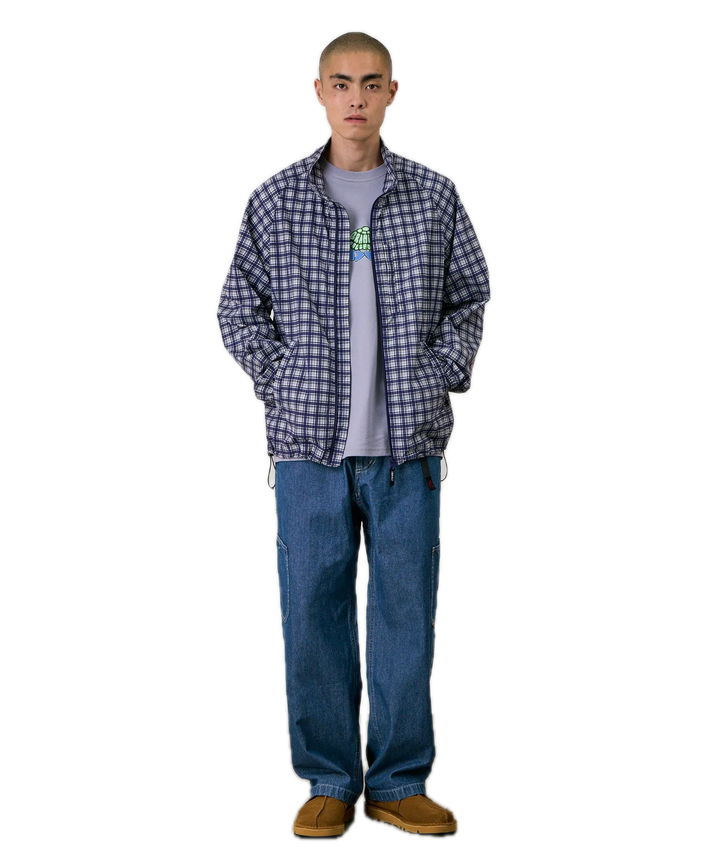 Person wearing a checkered shirt, gray t-shirt, blue jeans, and brown shoes 