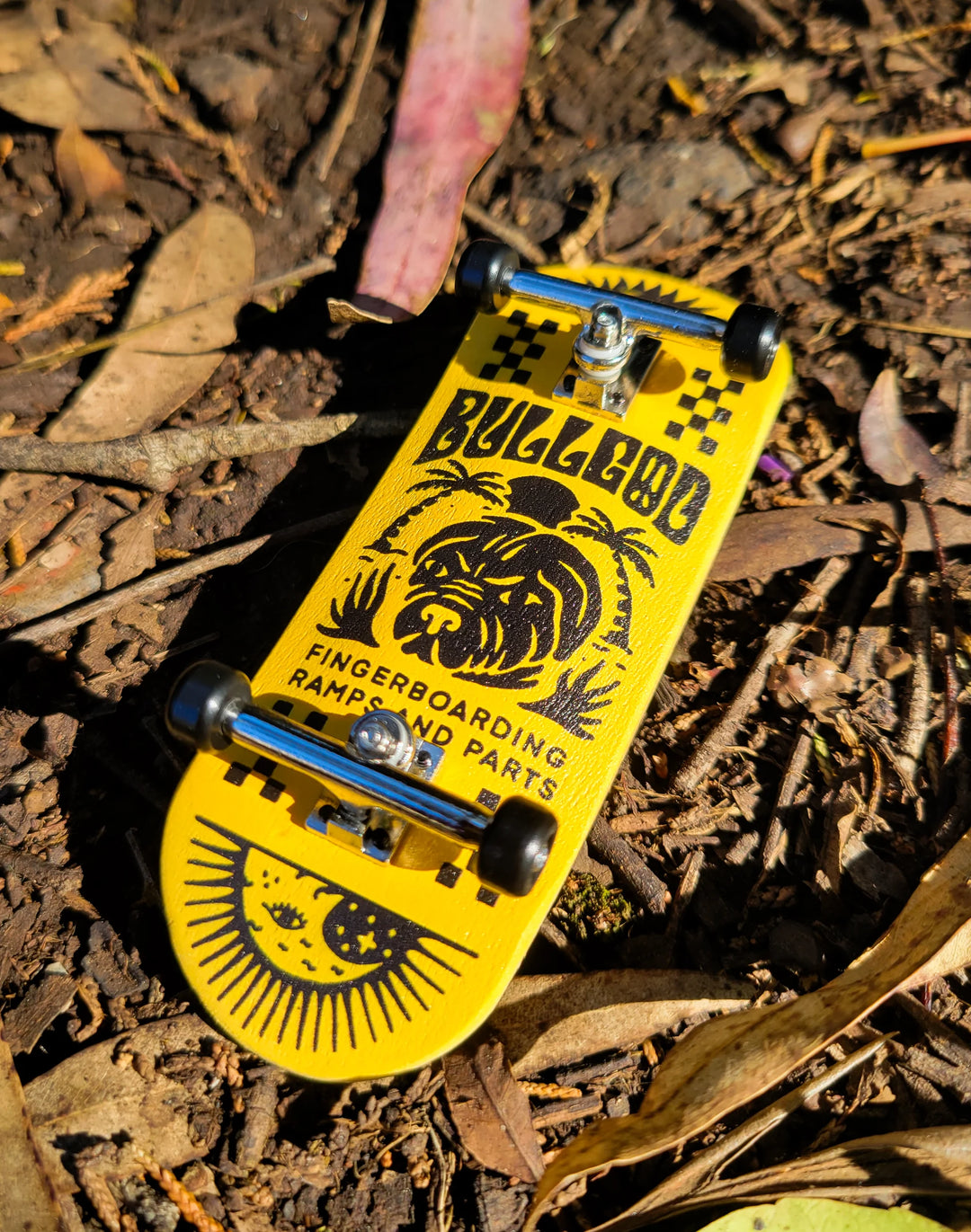 Yellow and black fingerboard with 'Bulldog' branding on a leafy background