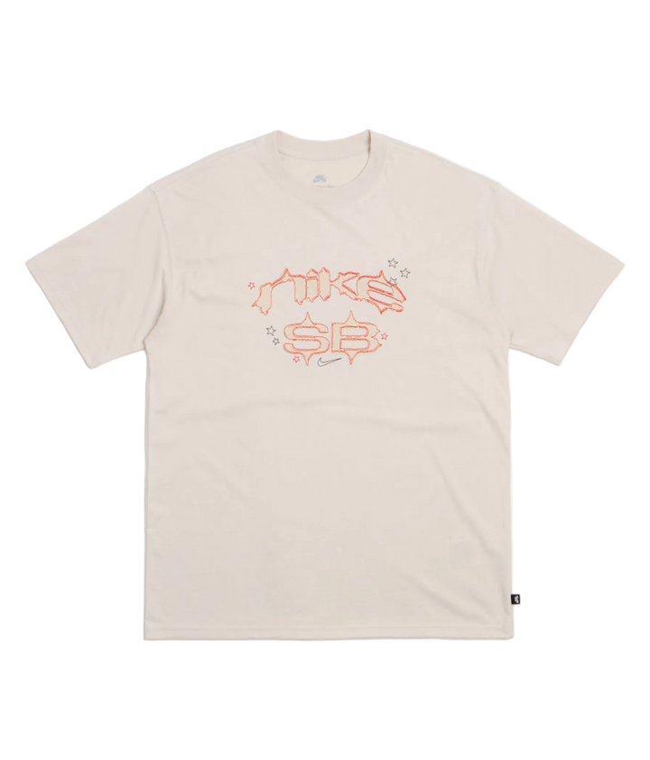 A light beige short-sleeve t-shirt with a stylized orange and pink 'Nike SB' graphic printed on the chest, displayed flat against a clean white background.