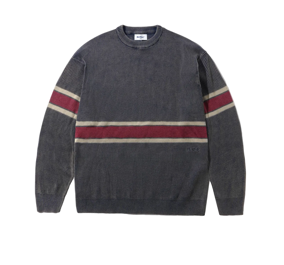 A dark gray ribbed knit crewneck sweater with horizontal stripes in burgundy and cream across the chest and sleeves, shown flat on a white background.
