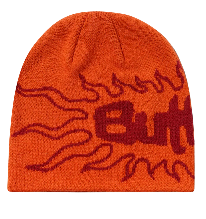 An orange knit beanie hat featuring a dark red flame