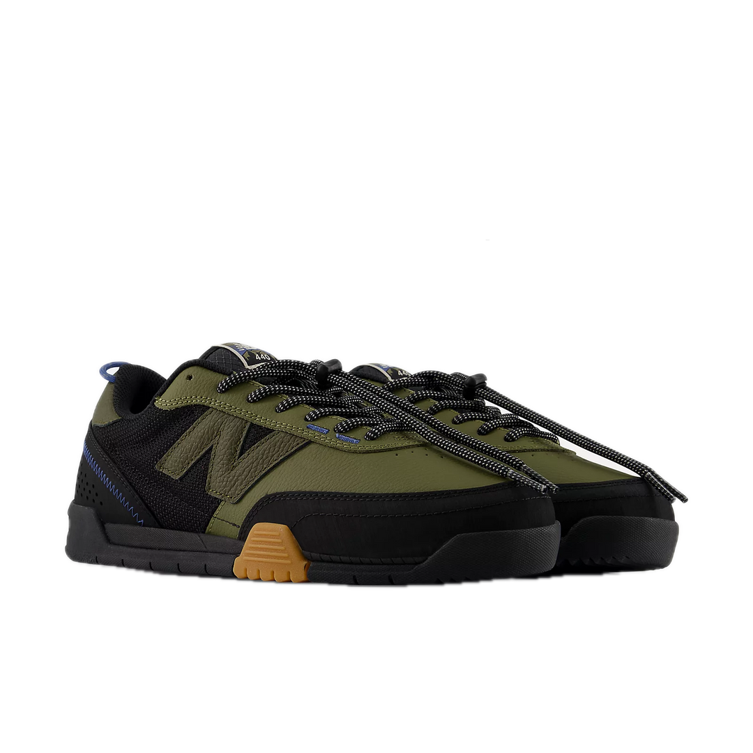 Green and black sneaker with brown sole on a white background